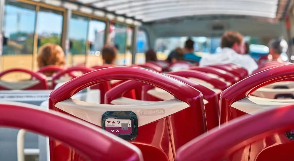 Rote Sitze auf dem offenen Oberdeck eines Sightseeing-Busses