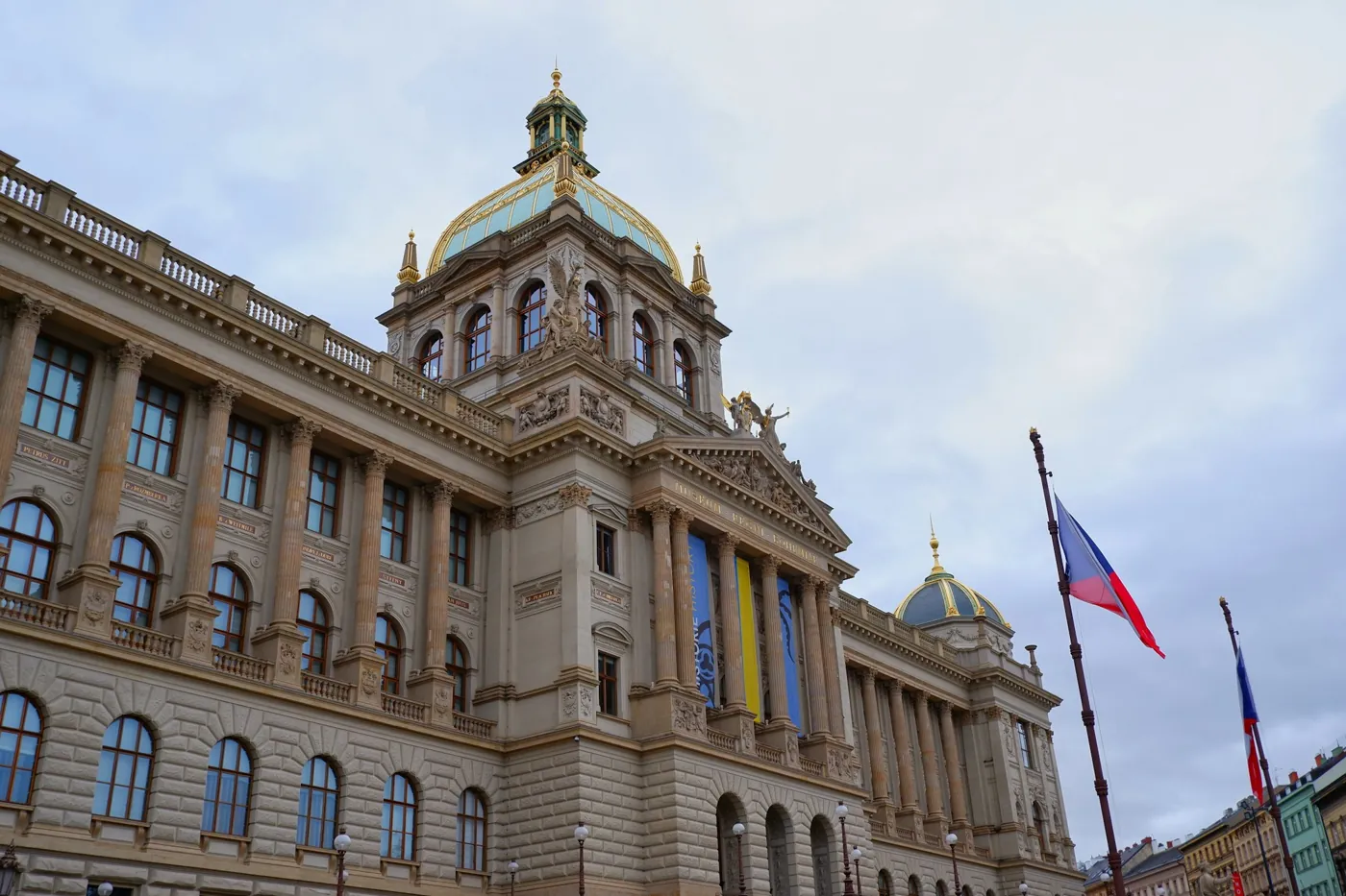 Historisches Gebäude des Nationalmuseums in Prag mit Kuppel, rechts tschechische Flaggen