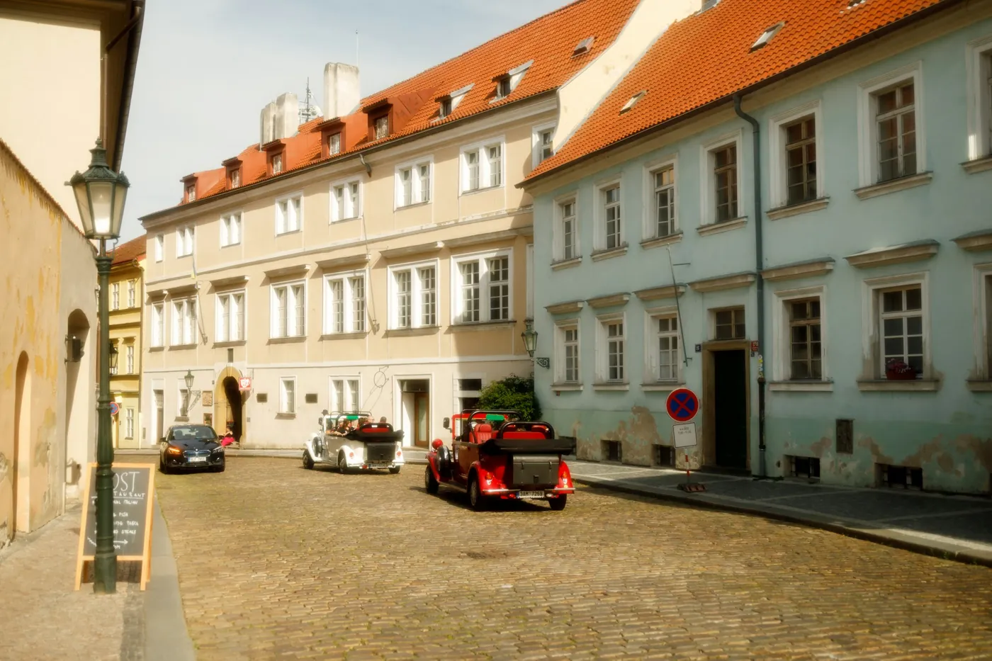 Zwei Oldtimer-Cabrios auf der gepflasterten Loretánská im Prager Burgviertel Hradčany