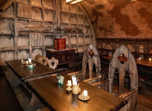 Holztische und geschnitzte Stuhllehnen in einem Gewölbe