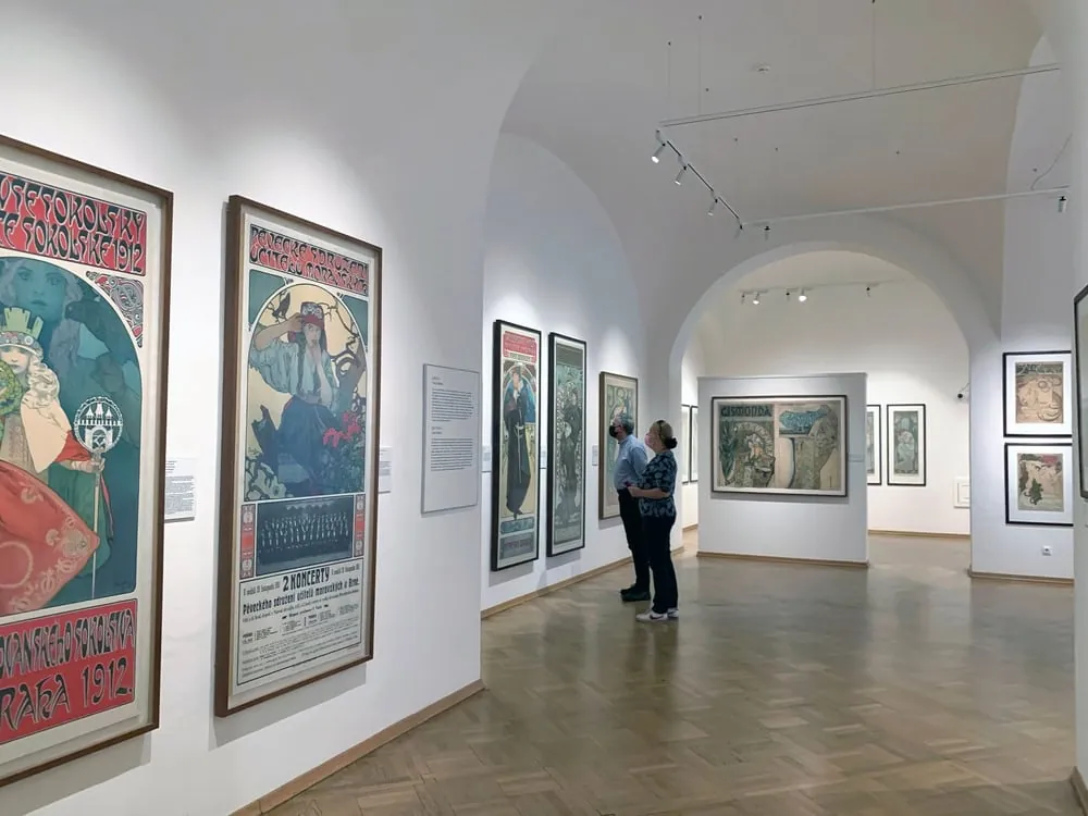 Ausstellungsraum mit Plakaten von Alfons Mucha