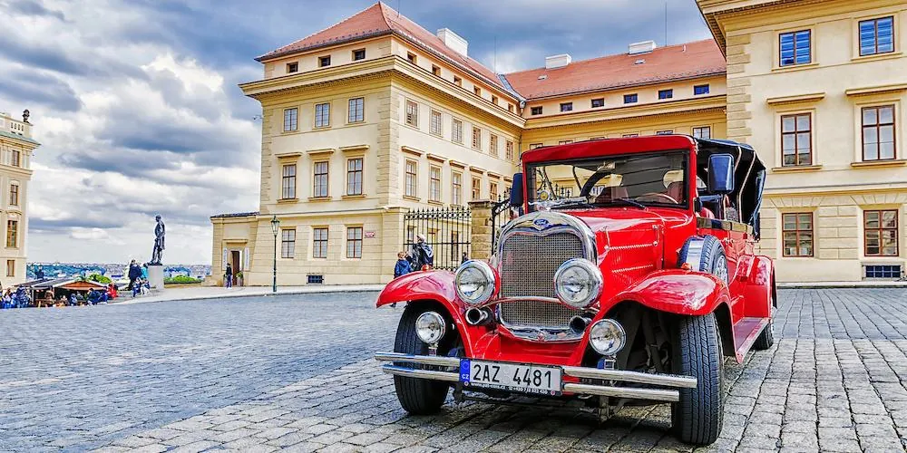 Roter Oldtimer auf dem Hradschiner Platz vor der Prager Burg
