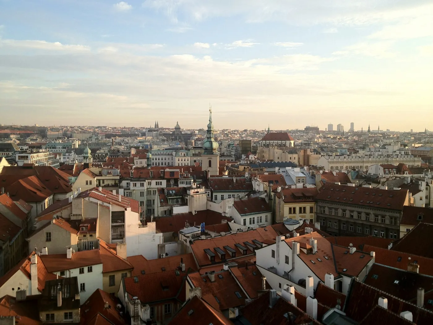 Blick über die roten Dächer der Prager Innenstadt im Abendlicht