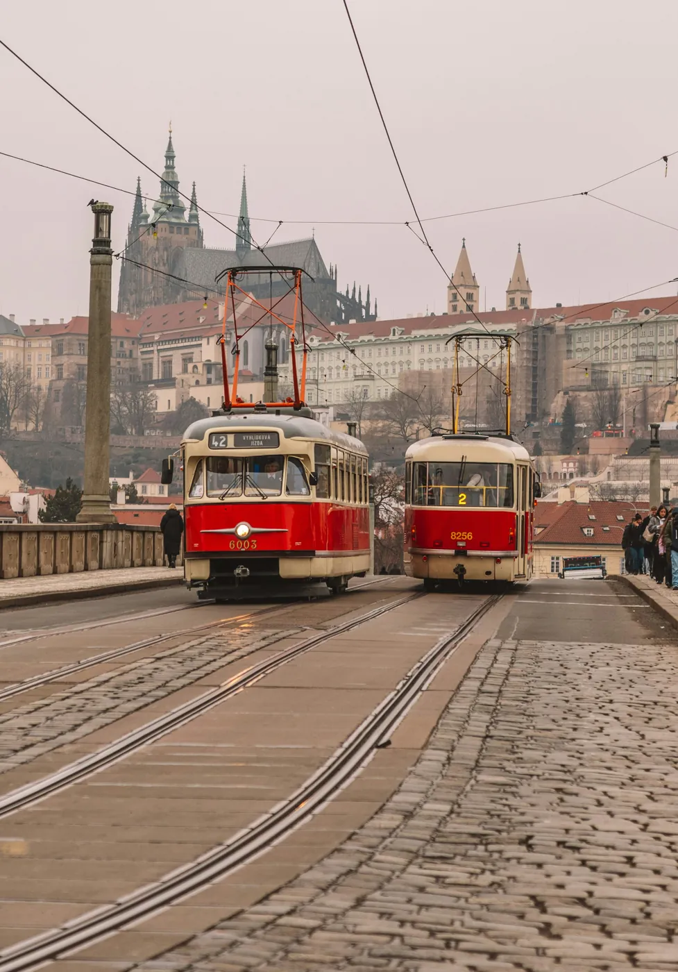 Historische Straßenbahn der Linie 42 auf einer Moldaubrücke, im Hintergrund die Prager Burg